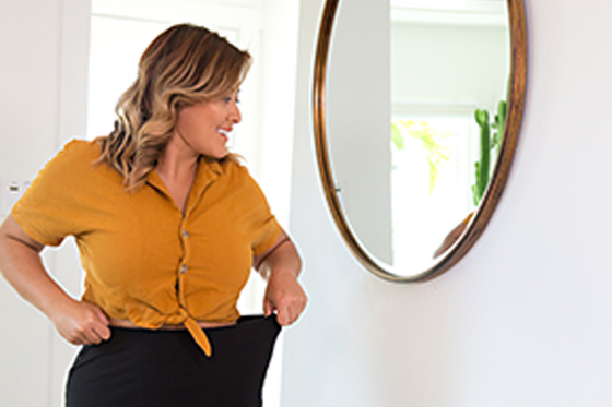 Weight loss woman looking in mirror