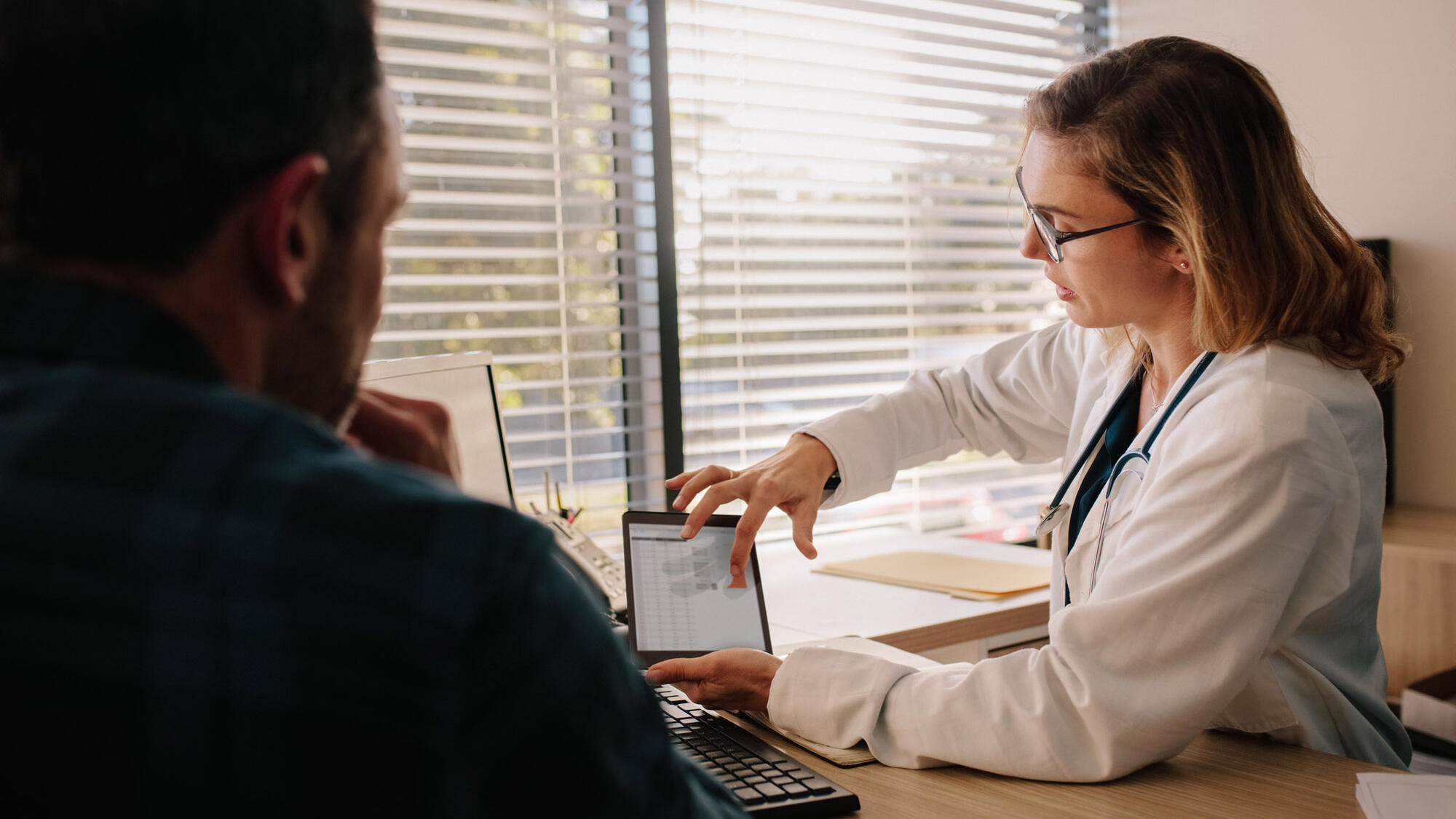 Woman doctor showing patient tablet screen