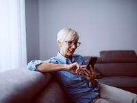 Woman in glasses using phone touchscreen